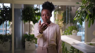 Afro-Amerikalı iş kadını gülümseyen kız etnik iş kadını işkadını kadın işveren kadın yönetici insan kaynakları müdürü adam toplayıcı buraya gel ofis çalışanlarına hoş geldin jesti daveti