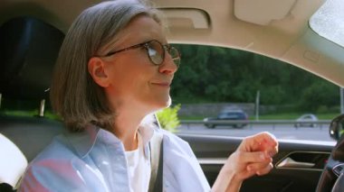 Dertsiz, aktif, Kafkasyalı, emekli, yaşlı, sahip, yaşlı, alıcı, araba süren, araba kullanan, araba kullanan, müzik çalan, kaliteli radyonun keyfini çıkaran, olgun, kadın bir araba şoförü.