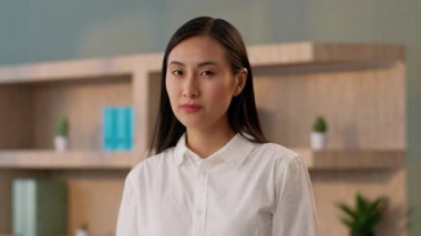 Kendine güvenen Asyalı başarılı iş kadını kadın CEO 'su patron Çinli iş kadını ofis çalışanı yönetmen iç mekanda silah hareketlerine bakıyor.