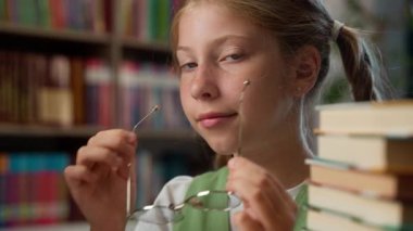 Zeki, başarılı, mükemmel öğrenci, beyaz, küçük kız, liseli kız öğrenci, gözlük takıyor, kameraya bakıyor, sınava hazırlanıyor.