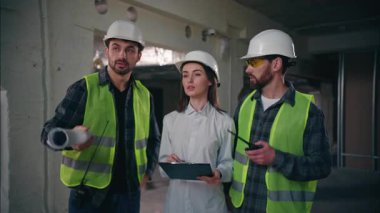 Profesyonel Kafkasyalı meslektaşlar inşaat işini tartışıyorlar teknisyenler müteahhitler müteahhitler telsizle iletişim kuruyor kadın kontrolör üretim denetleme planı