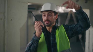 Kafkasyalı ustabaşı inşaat mimarı elektrikçisinin telsizinden bahsediyor. Buraya gel. Müteahhit erkek müfettiş.