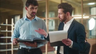 Kafkasyalı erkek iş arkadaşları, belgelerin tartışılacağını tartışıyor. Şirket evrakları, banka anlaşmaları, iki profesyonel iş arkadaşının ofis müzakere sözleşmesinde tartıştığı anlaşmalar.