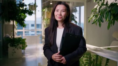 Çinli Asyalı iş kadını kameraya bakıyor Japon iş kadını gülümseyen Koreli kız profesyonel tüccar komisyoncu emlak yöneticisi yönetici ofis çalışanı danışmanı stajyer öğrenci