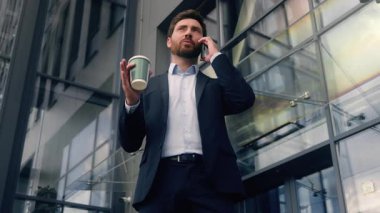 İş adamı işadamı gülümseyen mutlu adam cep telefonlu konuşan erkek kaygısız yetişkin girişimci konuşuyor ofis binası yakınında cep telefonu görüşmeleri akıllı telefon.