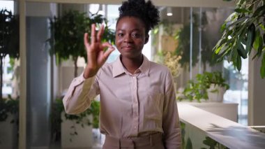 Gülümseyen neşeli iş kadını Afrikalı Amerikalı etnik kız ofis müdürlüğündeki mutlu iş kadını kurumsal başarı pazarlamacısı onaylı jest iyi tavsiye iyi tavsiye