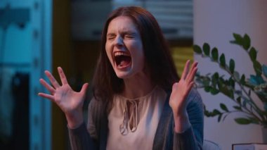 Kızgın kadın kızgın beyaz kız evde yüksek sesle bağırıyor. Bekar kadın bağırıyor duygusal stres bağırıyor. Öfkeli surat ifadeleri takınıyor.
