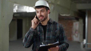 Cep telefonu endüstrisinden konuşan mühendis gülümseyen ustabaşı beyaz erkek işçi işçi mimar inşaat müfettişi ustabaşı cep telefonu hoş sohbetini ara