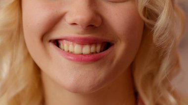 Kadın dişlerini kapat, gülümse, dişlerini beyazlat, dişlerini beyazlat, sağlıklı gülümse, tanınmayan bayan bayan, gülümse, mutlu, neşeli, klinik, dişçi, diş hekimliği, pembe şeker odasında.