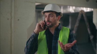 Sinirli Kafkasyalı mimar cep telefonuyla konuşuyor inşaat ustabaşısı elektrikçi erkek haberleşen akıllı telefon müfettişi tamirci sorununu tartışıyor.