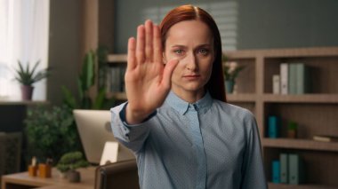 Kendine güvenen ciddi kadın iş kadını yöneticisi beyaz kız sakin iş kadını avukat kameraya el uzatma hareketini durduran güçlü kol reddi sembolü büroda uyarıyı reddet