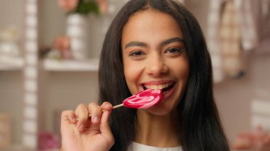 Gülümseyen Latin kadın etnik neşeli İspanyol kadın şımarık kız şeker yiyor diyet sağlık hizmetleri gülüşü dişçi diş bakımı güzellik ürünleri pembe banyo reklamlarında