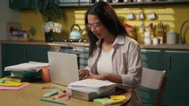 İspanyol kadın öğrenci, evrak atma konusunda stresli. Mutfak dağınıklığı. Latin kız iş kadını dizüstü bilgisayar.