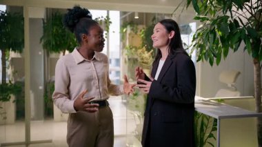 İki iş kadını, çok ırklı iş kadınlarının ofiste konuştuğu beş başarılı iş birliği meslektaşı öğrenciler, iş arkadaşları sırıtan Afrikalı Asyalı kızlar ve gülen kadınlar destek oluyor.