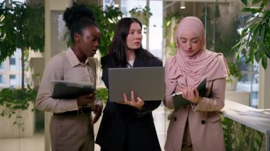 Ofisteki çok ırklı iş kadınları grubu çeşitli iş kadınları tartışma takımı projesiyle tanışıyor. Laptop, Asyalı Arap takım kızları sohbet işbirliği hakkında konuşuyorlar.