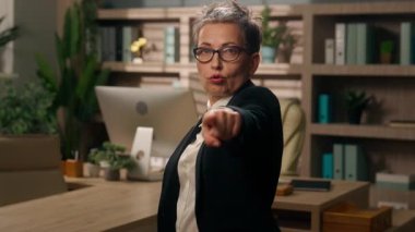 Kafkasyalı yaşlı iş kadını, işaret parmağıyla ofiste kameraya bakıyor, olgun, kendine güvenen, ciddi iş kadını, kadın işveren şirket CEO 'su, adayı elle seçiyor.