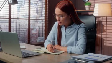 Konsantre olmuş Kafkas iş kadını ofiste dizüstü bilgisayarla çalışıp not defteri ile notlar yazarak bilgi yaz iş kadını kadın girişimci iş kadını şirkette çalışıyor.