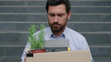 Orta yaşlı, stresli iş adamı işten çıkarılma kutusunu tutarken işini kaybetti. Ofis dışında depresyonda olan iş adamı erkek işsizlik ekonomik krizini finansal krizden çıkardı.