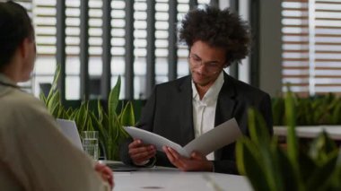 İş yerindeki iki iş adamı Afro-Amerikan sigorta uzmanı özgeçmiş belgelerini okuyorlar. Kötü çalışmayı reddediyorlar.