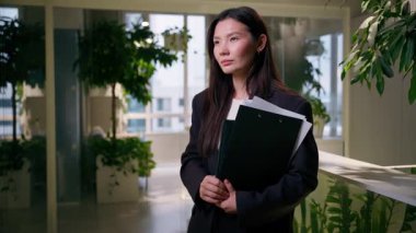 Asyalı iş kadını, ofis resminde bir klasör tutuyor. Çinli Koreli iş kadını. Japon kız. Kadın HR yöneticisi.