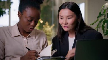 İş kadınları, iş arkadaşları, Afrikalı iş kadınları, ofiste iş birliği, iş arkadaşları, çok ırklı kadın takım çalışması dizüstü bilgisayar projesi, not defteri yöneticileri, kurumsal beyin fırtınası hakkında konuşuyor.