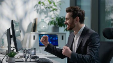 Bilgisayar başında çalışan mutlu Kafkasyalı yetişkin adam iyi haber okuyor zafer kazanan erkek çalışan adam iş adamı neşeli iş adamı başarılı ofis çalışanı kazandı yönetici kazandı