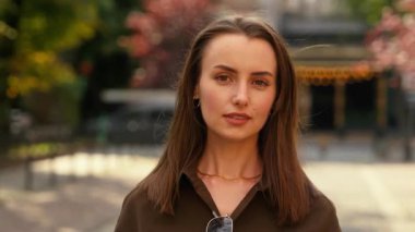 Gerçekten sakin, şık, beyaz kadın iş kadını kadın iş kadını sokak sonbahar şehrinde kamera karşısında barışçıl sevgili eşinin açık hava moda anlayışına gülümseyen fotoğrafına bakıyor.