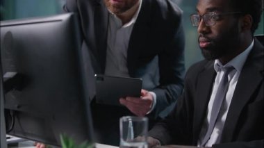 İki farklı iş arkadaşı, Afrika kökenli Amerikalı Kafkasyalı, proje analizi hakkında konuşuyor. Bilgisayarla başlayan PC erkekleri, iş adamları, işadamları, işverenler, çok ırklı takım çalışanları.