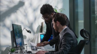 Sinirli Afrikalı Amerikalı lider, Kafkasyalı ofis çalışanı işadamının hatalı olduğunu ileri sürerek azarlıyor.