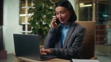 Neşeli Asyalı Çinli Japon kadın gülümseyen cep telefonlu akıllı telefon müvekkil danışmanlığı kadın iş kadını iş kadını iş kadını iş kadını ofis yöneticisi girişimci