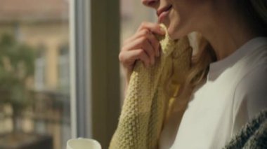 Mutlu, rahat bir kadın, sıcak bir sabahın keyfini çıkarıyor kahve içiyor, evine bakıyor, beyaz kadın ev sahibi, çay içiyor, kahvaltı yapıyor, rahat kıyafetlere dokunuyor, rahatlıyor, dinleniyor.