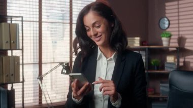 Kafkasyalı bir kadın cep telefonlu akıllı telefon ev kadını cep telefonu iş kadını cep telefonu ofis kadını gülümseyen uygulama gülen internetteki iletişim ekommerce e-iş aleti çalışanı