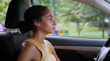 Üzgün Afro-Amerikalı kadın, kadın sürücü otomobil taşıma aracının kameraya baktığını vurguladı.