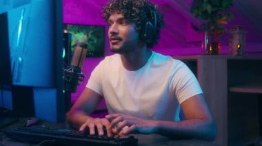 Arap kökenli erkek vlogger flaması çalan bir adam oyun kurucuyu tartışıyor mikrofon bağımlısı mutlu adam dijital oyun blogu ev sahibi siber spor neon sunucusu e-spor radyo sunucusu çevrimiçi yayınında