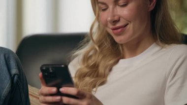 Gülümseyen kadın müşterinin cep telefonunu açıp SMS yazarken mutlu iş kadını e-iş kadını akıllı telefon uygulaması online iletişim bağlantısı kullanarak apartmanda sosyal medya sohbeti yapıyor.