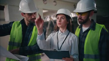 Kafkasyalı takım arkadaşları inşaat işindeki işbirliğinden bahseden inşaatçılar erkekler kontrol eden teknisyenler teknisyenler ustabaşı elinde telsiz planı alan mimarisi projesi tutan ustabaşı.