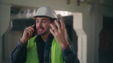 Sinirli Kafkasyalı işçi ustabaşı inşaat müteahhiti erkek teknisyen bağırarak cep telefonuyla konuştuğunu iddia ediyor. Akıllı telefon mühendisi, mimar, anlaşmazlık yaratma sorunu.