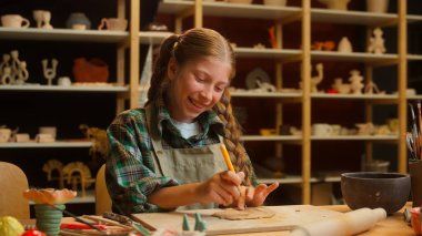 Mutlu, neşeli, yaratıcı, küçük, beyaz kız, çocuk, kız, okul öğrencisi sanat zanaatı, kil modelleme seramik heykeller, atölye atölyesinde gülen kameralar.