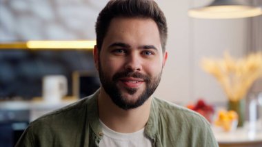 Dertsiz, mutlu, rahat, Kafkasyalı, sakallı, erkek, müşteri portresi ev sahibi, kamera dostu, güler yüzlü, sağlıklı hafta sonu rahatlama, oturma odasındaki kanepede oturmak.