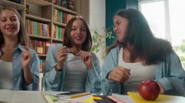 Komik kaygısız mutlu dört genç okul kütüphanesinde şarkı söyleyerek dans ediyor sınıf arkadaşları birlikte dans ediyor müzik dinliyor sınavlara hazırlanırken eğlenceli öğrenciler ara veriyor.