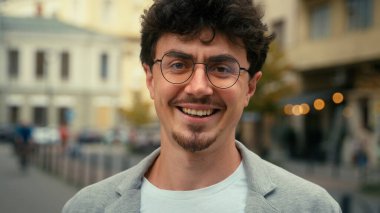 Kentsel sokak fotoğrafında gülümseyen İspanyol bir adam, şehirde çalışan erkek işverenin gülümseyen dişlek diş sağlığı mutlu, mutlu, mutlu, neşeli, pozitif iş adamı gözlüklü iş adamı.