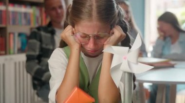 Okulun zorbalık sorunu ağlayan beyaz kız çocuğu sanat dersinde acı çekiyor. Gençler ağlıyor. Sınıf arkadaşları kağıt uçak fırlatıyor.