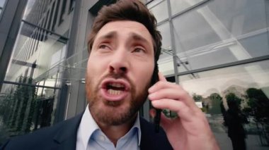 Orta yaşlı Kafkasyalı iş adamı bağırıyor cep telefonuna kızgın bağırıyor telefon görüşmesi yapıyor iş yerinin yakınında tartışmalar oluyor iş adamı konuşuyor iş yerinde akıllı telefon stresi iş stresi