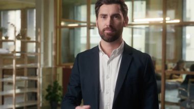 İş dünyasının pozitif beyaz erkek işadamı ofis lideri yönetici erkek kamera yöneticisine bakıyor. İşçi gülümsemesi anlaşması imzalıyor. Harika sonuç sembolü adam öneriyor.