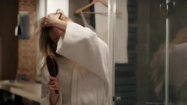 Kafkasyalı mutlu bir kadın saç fırçası şarkısı söylüyor banyoda eğleniyor neşeli bir kadın model şarkı söylüyor mikrofon dansı yapıyor karaoke duşu yapan sıradan bir kız banyoda saç fırçalamaktan zevk alıyor