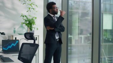 Pencereden bakan düşünceli Afro-Amerikalı iş adamı çözüm üretmeyi düşünüyor etnik iş adamı profesyonel erkek iş adamı fikir üretmek zor fikirlere karar vermek başlangıç stratejisi üzerinde düşünmek