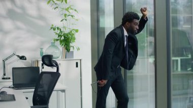 Stresli Afrikalı Amerikalı iş adamı. Ofiste cama yaslanarak acı çekiyor. Problemli erkek profesyonel iş krizi düşünüyor.