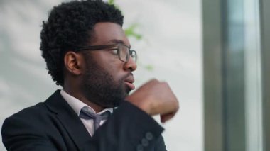 Stresli Afrika kökenli Amerikalı iş adamı panik ataktan endişe duyuyor. Ofiste çalışan iş adamı, pencereye yaslanıyor. Sinir krizi geçiriyor, duygusal çöküntü yaşıyor.