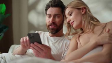 Mutlu bir aile, beyaz bir çiftle evlenmiş. Yatak odasında cep telefonuyla internete girip karı kocanın internetten mal satın almasından konuşmuş. Kadın, sosyal medya uygulaması siber uzay interneti kullanıyor.