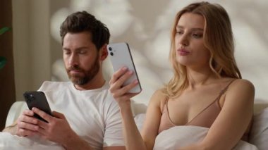 Aile aleti bağımlılığı Kafkasyalı çift yatak odasında cep telefonlarını daktilo ediyorlar. Sosyal medya kocasını görmezden geliyorlar. İnternet üzerinden internet kadınlarına göz atıyorlar.